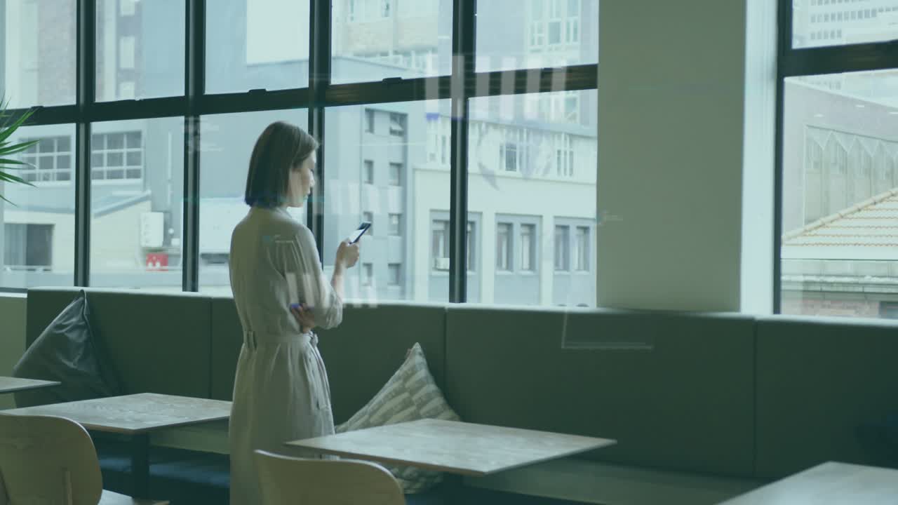 Woman standing window tapping phone making charts and globes peaking over her then fading for tech