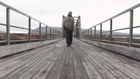 anonymous man standing on bridge in gloomy day