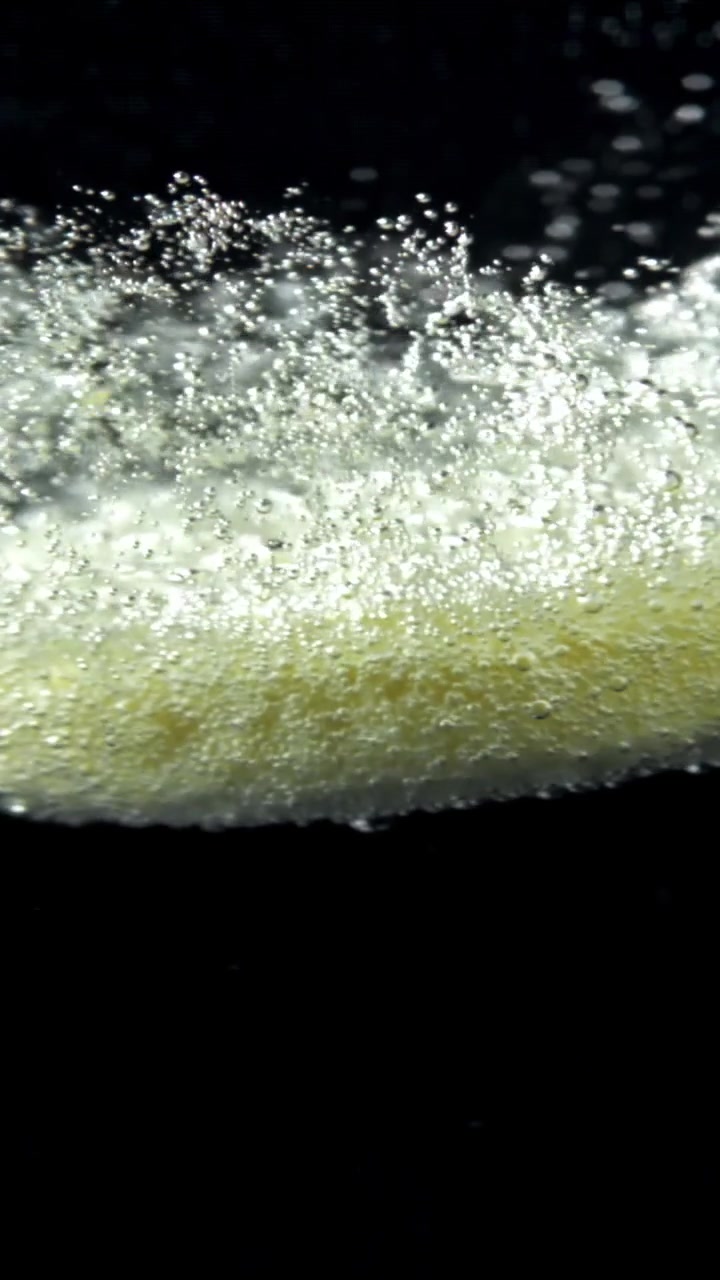 Bollicine effervescenti scintillanti che salgono in un liquido trasparente
