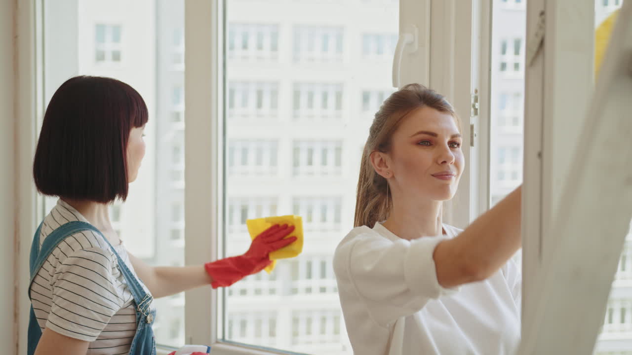 두 명의 여성이 창문을 청소하고 있습니다.