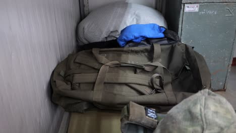 soldier putting his personal effects on a bed, army backpack and uniform