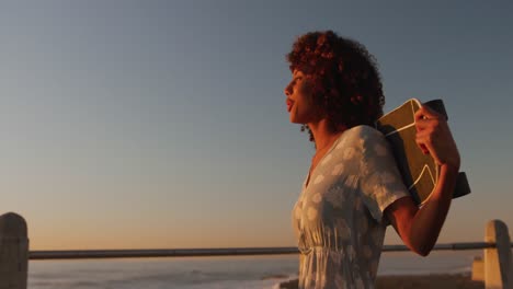 Woman-walking-and-holding-a-skateboard-on-hand