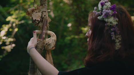 una joven druida contempla su bastón de madera.