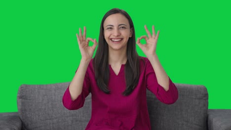 mujer india feliz mostrando bien señal de pantalla verde