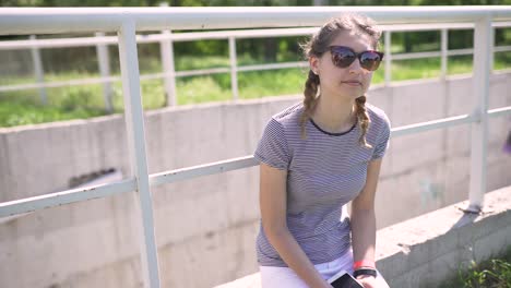 portrait of an attractive smiling caucasian woman in a park with glasses