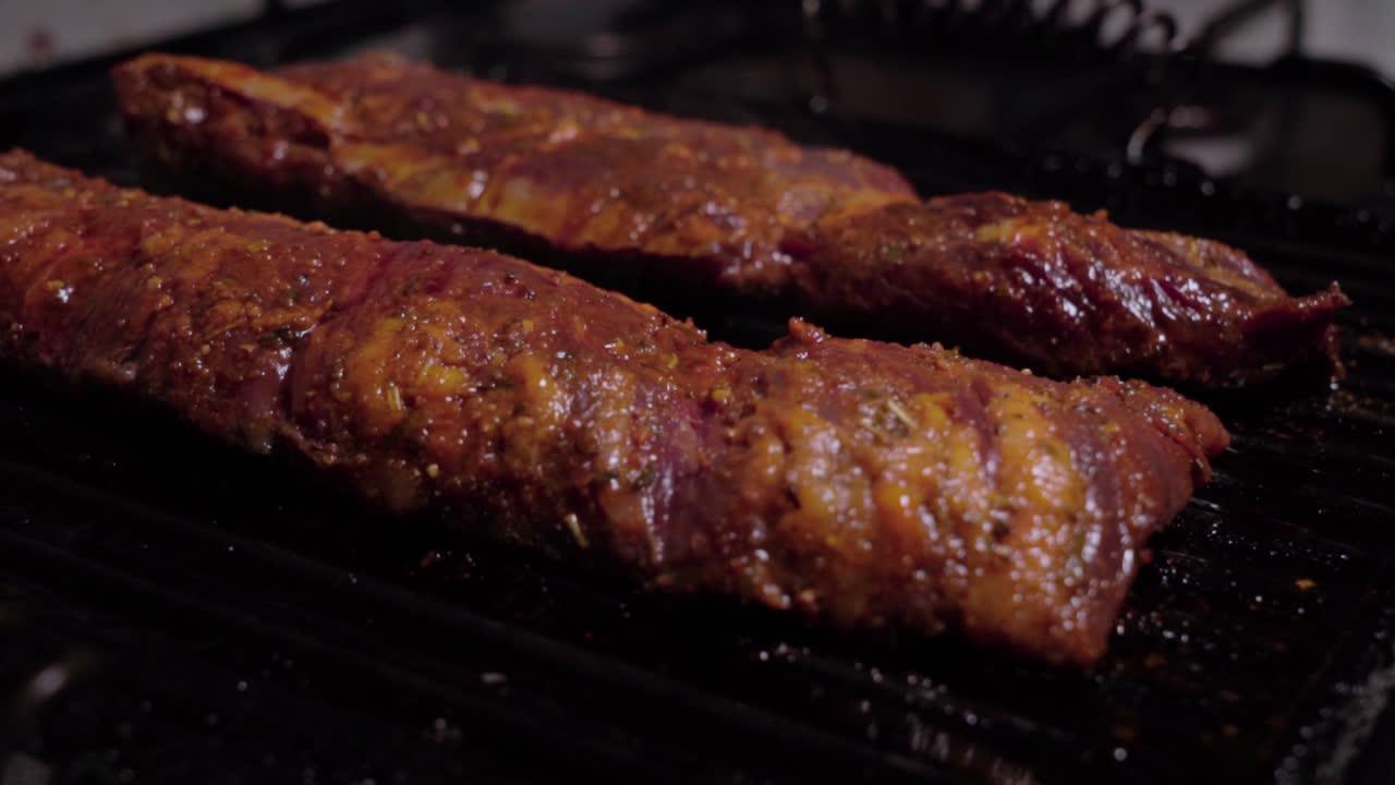 Two raw marinated beef steaks cook on cast iron grill pan, Closeup