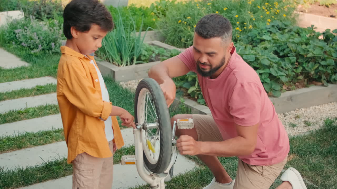 Father And Son Repairing Bike Outdoors
