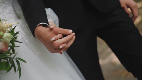 young newlywed couple in festive clothes walks along park