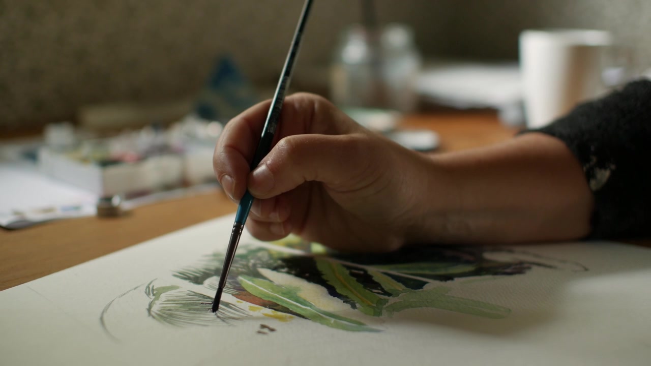 Artista che dipinge dettagli con acquerello su carta.