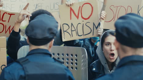 grupo de personas multiétnicas empujando y gritando a los policías en una protesta contra el racismo en la calle