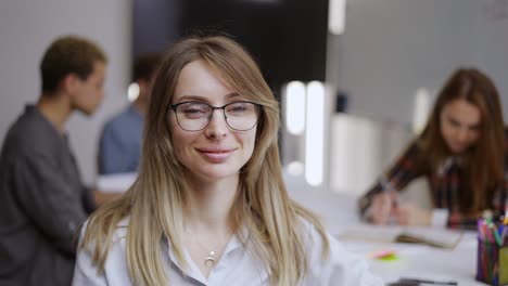 Portrait-of-young-female-office-manager-looking-to-camera-and-having-good-mood