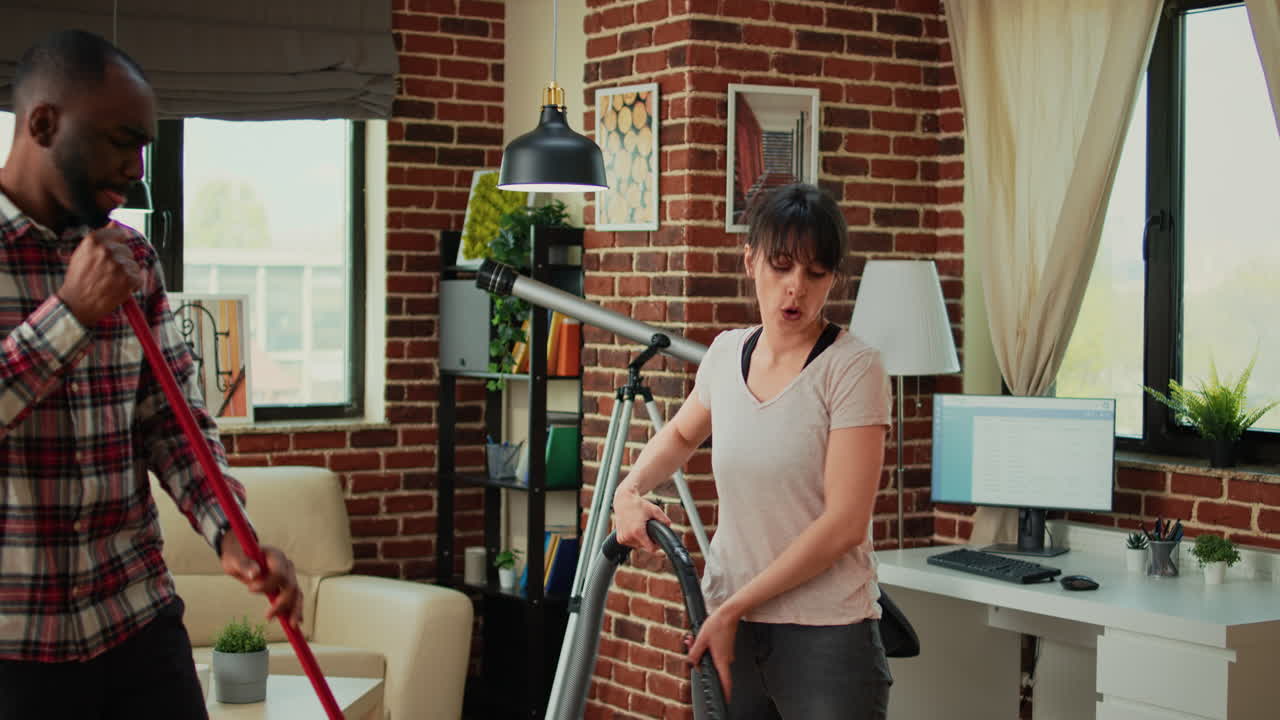 Happy life partners using tools to clean apartment