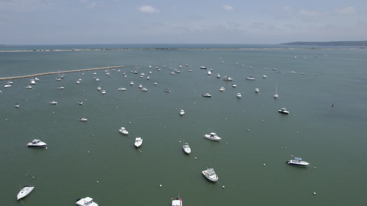 미국 써니 플리머스에 정박된 보트 위로 움직이는 구름의 하이퍼랩스 드론 샷