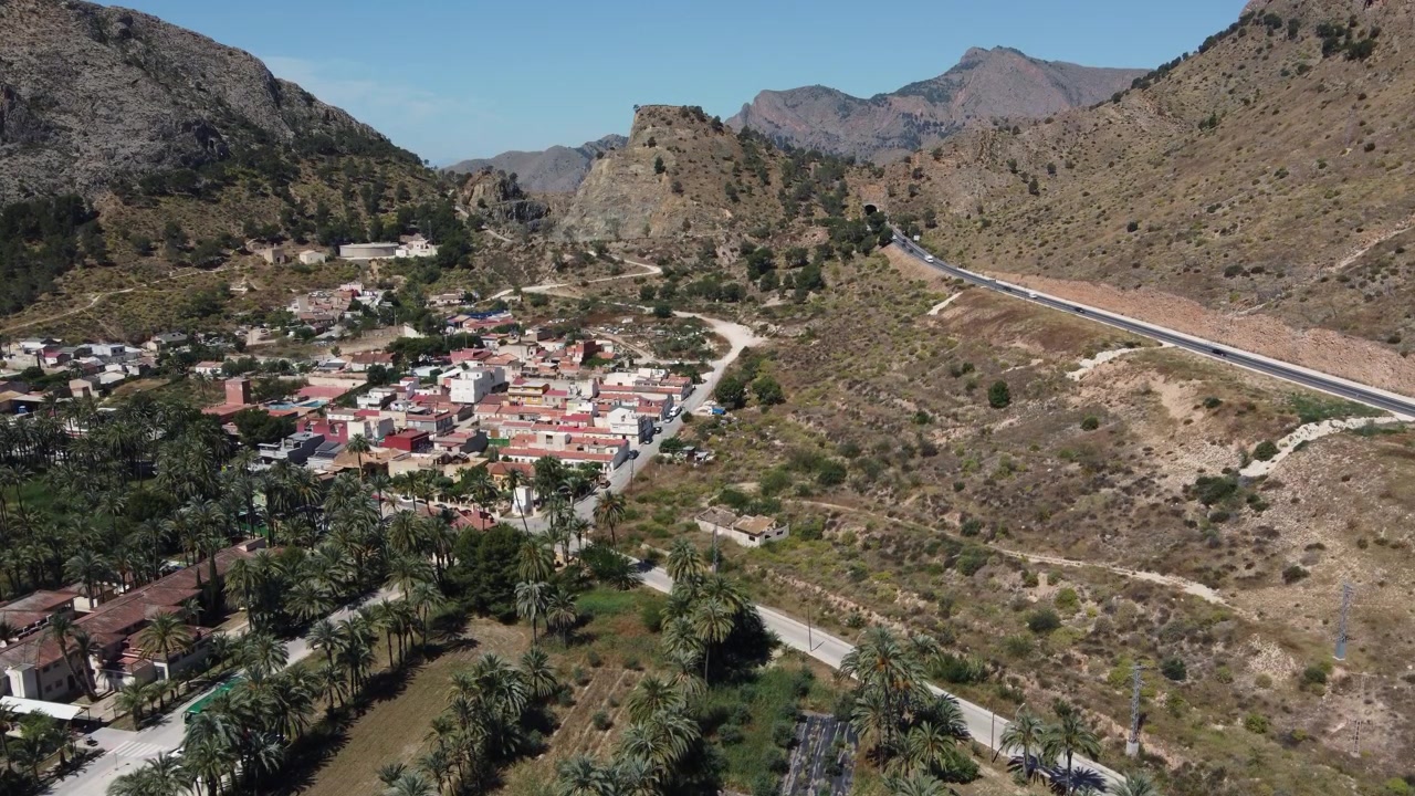 Filmato statico da drone che mostra una vista aerea del quartiere di San Anton e della strada statale N340 a Orihuela, Alicante, Spagna. Ideale per progetti di sfondo urbani, di viaggio e sul traffico