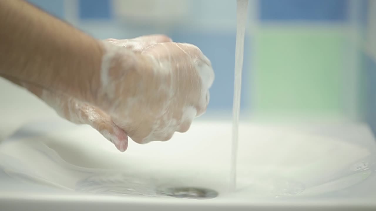 Primo piano di una persona che si lava le mani con acqua e sapone