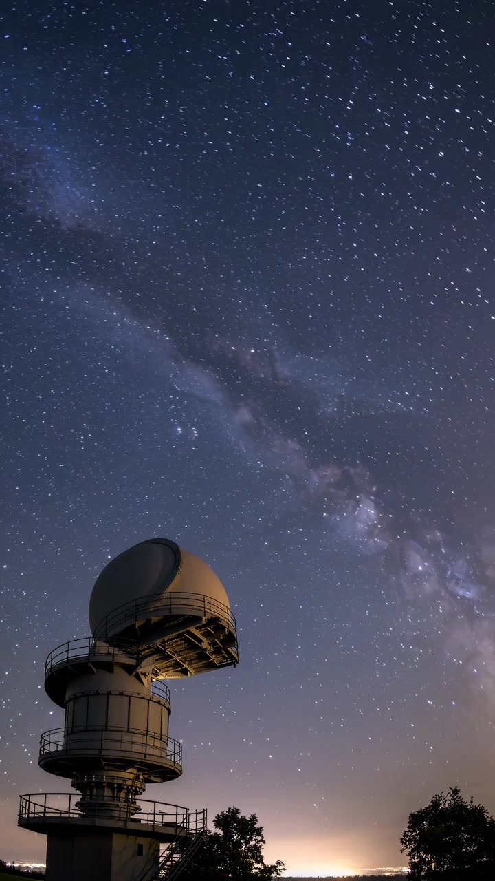 Timelapse de la Vía Láctea y estelas de estrellas sobre la cúpula de un observatorio