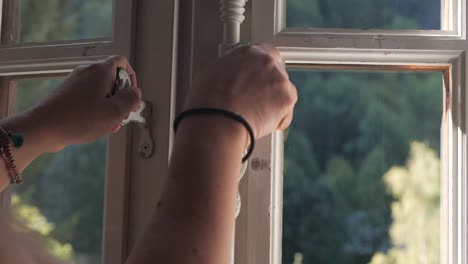 mujer joven abriendo una ventana para dejar que entre aire en una idílica casa de verano