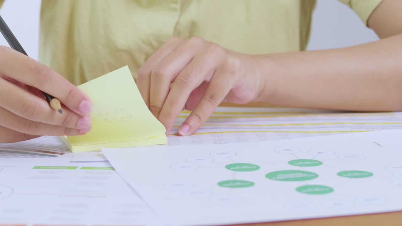 A person organizes thoughts using sticky notes and documents a bright home office setting