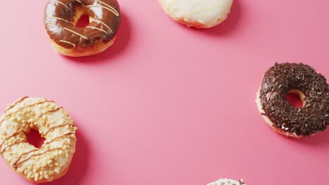 Video-of-donuts-with-icing-on-pink-background