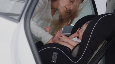 young-mother-putting-baby-in-car-seat-securing-child-for-road-trip-responsible-parent-caring-for-toddlers-safety-in-vehicle