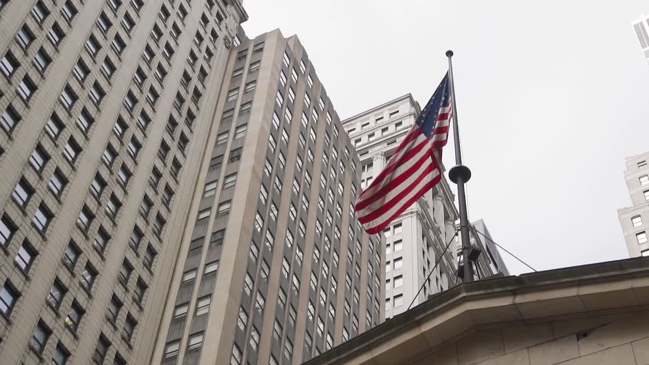 American National Flag Waving on a Pole Under Skyscrapers of Manhattan, New York USA. Slow Motion
