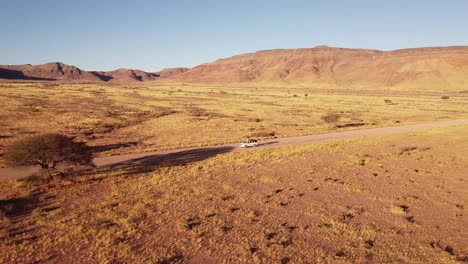 Adventure-Across-Endless-Dunes:-4K-drone-shot-of-Desert-Drive-in-Namibia,-Africa-with-Rooftop-Tented-4x4-Toyota-Hilux