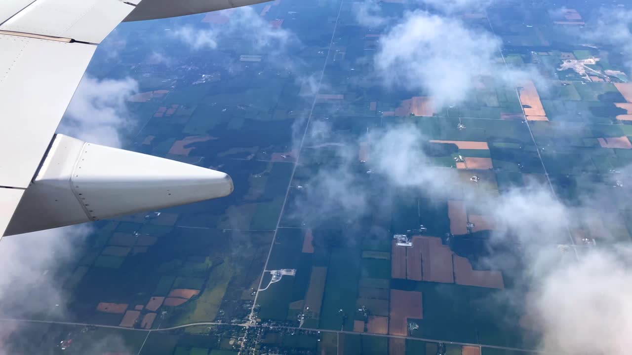 Clouds from airplane window view of farmland fields
