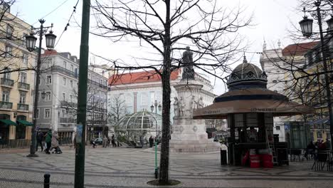 city center square, luis de camoes, in lisbon. monument, terrace and kiosk with people having. typical portuguese architecture  buildings, stone pavement with patterns. christmas decor.