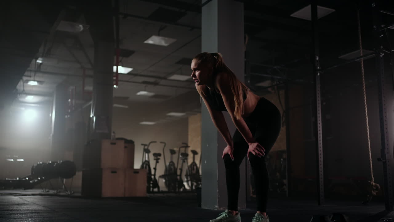 건강한 피트니스 여성 강도 훈련 운동 후 피곤한 체육관에서 휴식 강렬한 운동 후 휴식. 상쾌하고 상쾌한