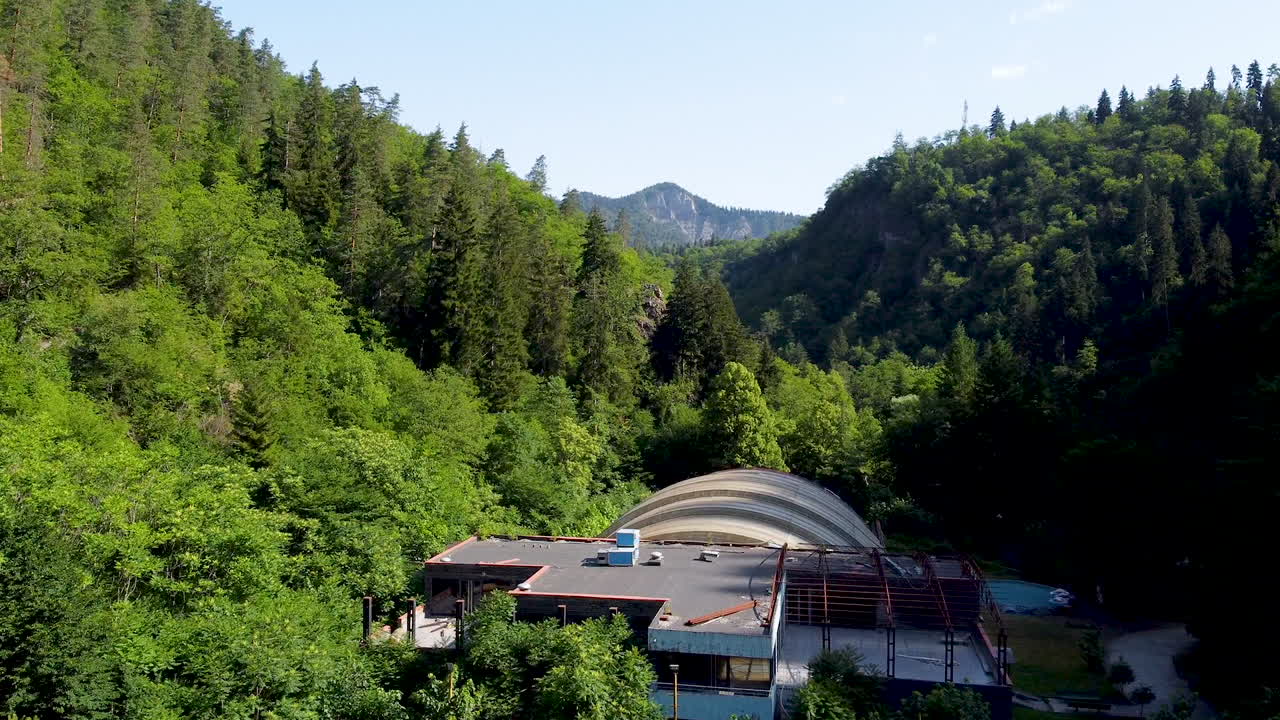 La zona frondosa attorno a una sorgente minerale e un parco divertimenti vuoto annidato in una valle in mezzo a una foresta