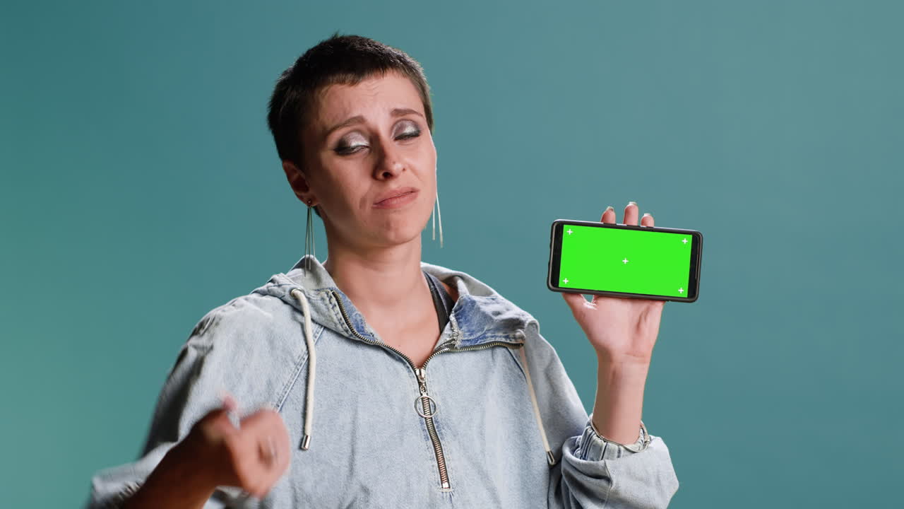 mujer sosteniendo un teléfono inteligente con una pantalla verde