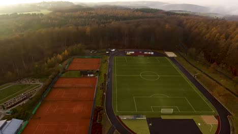 Paisaje-Rural-Con-Bosque-Y-Zona-Deportiva-Para-Tenis,-Fútbol,-Etc.