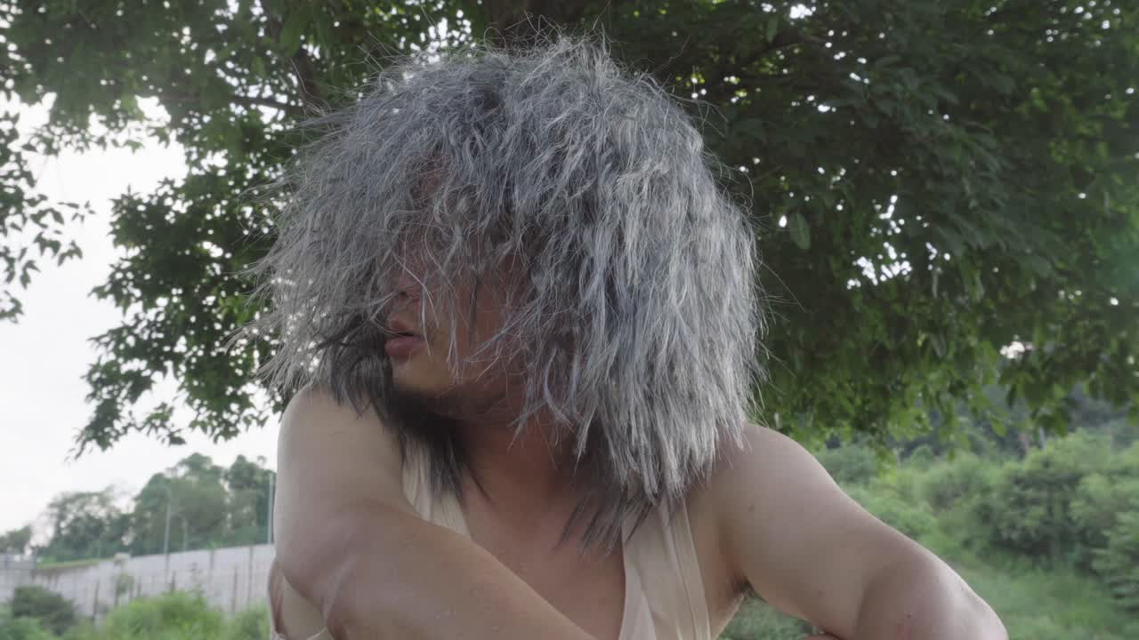 이 영상은 노인이 야외에 앉아서 황폐한 환경에서 자기 자신과 이야기하는 것을 보여줍니다. 그들의 감정은 점점 더 흥분되고, 마치 누군가와 이야기하는 것처럼 보입니다.