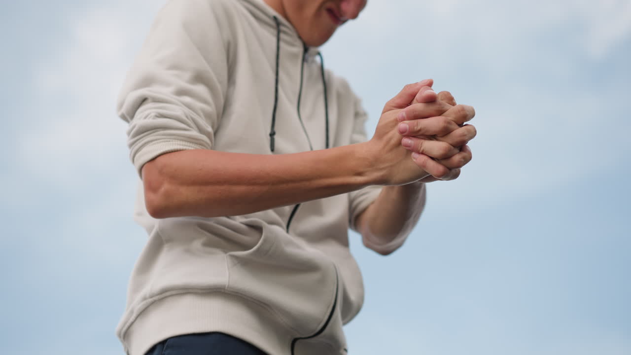 Man training arms outdoors, Active man practicing arm movements outdoors, Caucasian male engaged in vigorous arm practice outside under overcast sky with energetic urban atmosphere