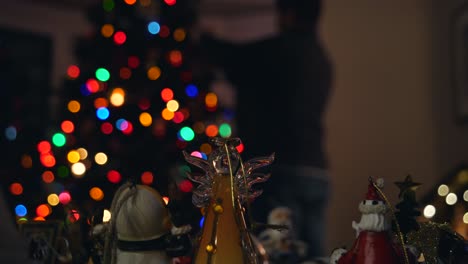 Picking Christmas Ornament and Placing on Tree in Soft Background