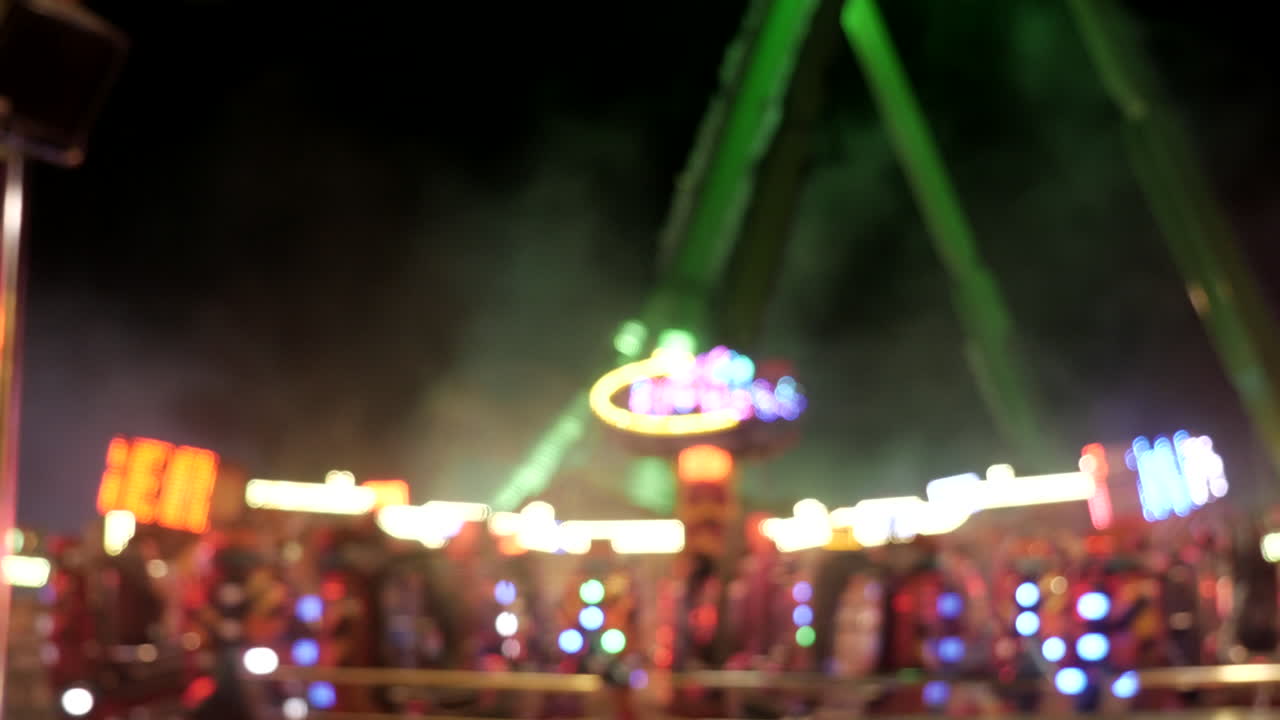 Giant spinning carousel on fairground at night,blurred focus,static shot