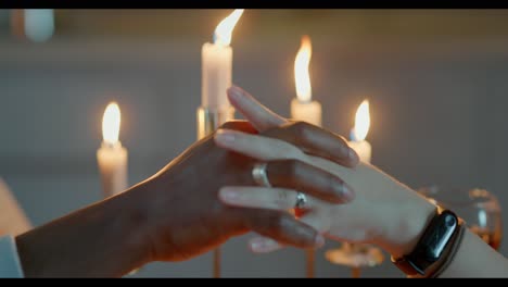 romantic couple holding hands by candlelight