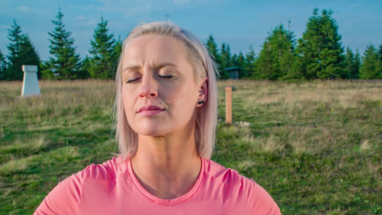 tiro de carro de mujer rubia bastante joven disfrutando al aire libre después de andar en bicicleta, ojos cerrados, cerrar