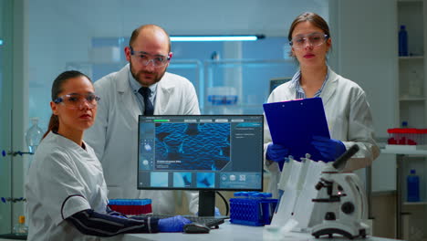 team of scientists sitting in laboratory looking at camera