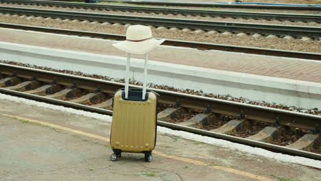 Bolsa-De-Viaje-Con-Sombrero-Sobre-Un-Fondo-De-Ferrocarril
