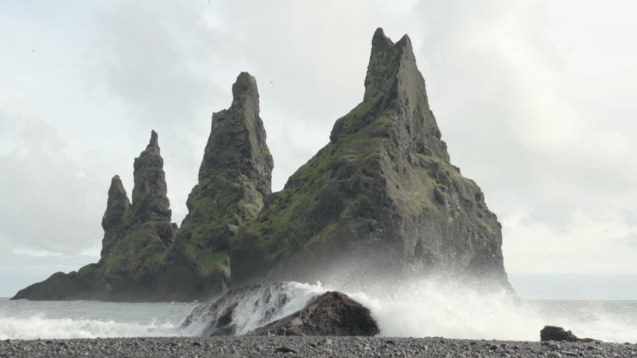 fotografía en cámara lenta de las olas que se estrellan en la playa en la formación rocosa de reynisdrangar