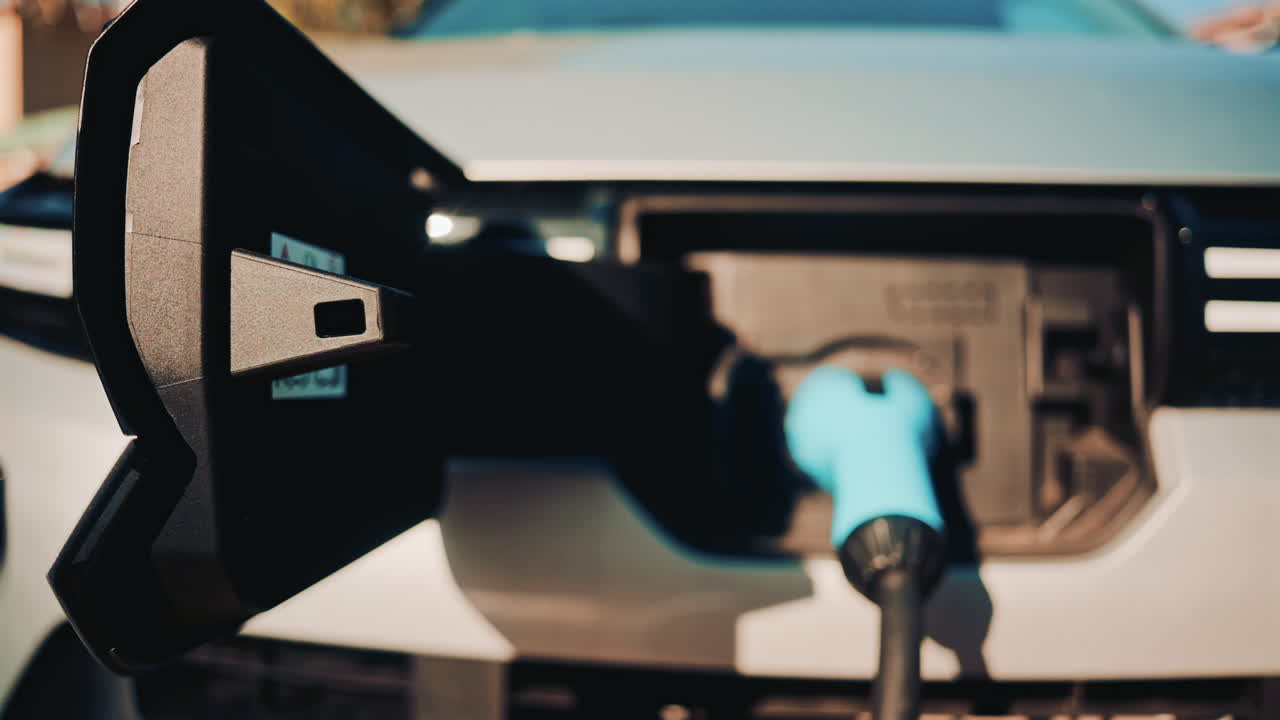 Close up shot of an electric vehicle charging port with cable connected
