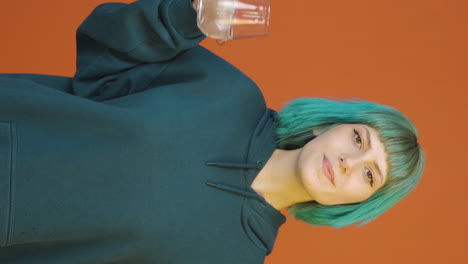 el video vertical de la joven está bebiendo agua.