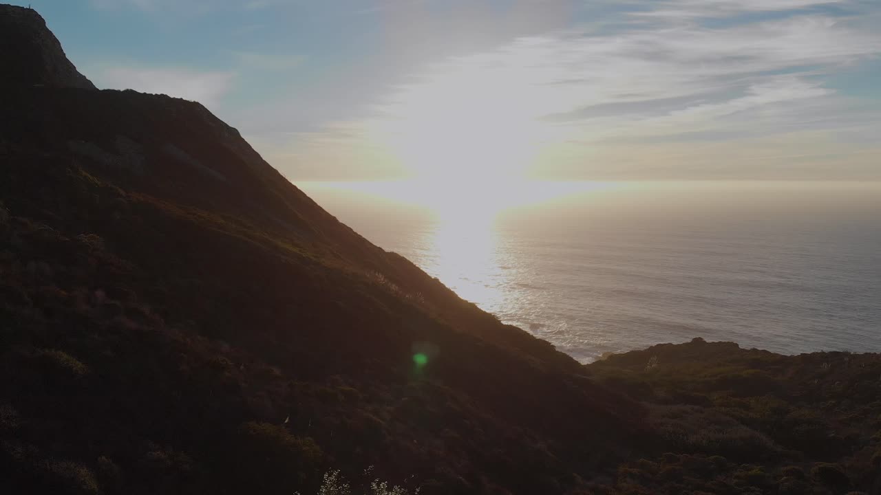 해안 고속도로를 따라 키 큰 풀 위로 석양 속으로 날아가다