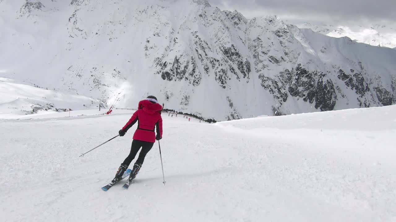 chica esquiando elegantes vueltas cortas en una pista de esquí empinada