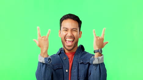 hombre con un gesto de mano de rock and roll por verde