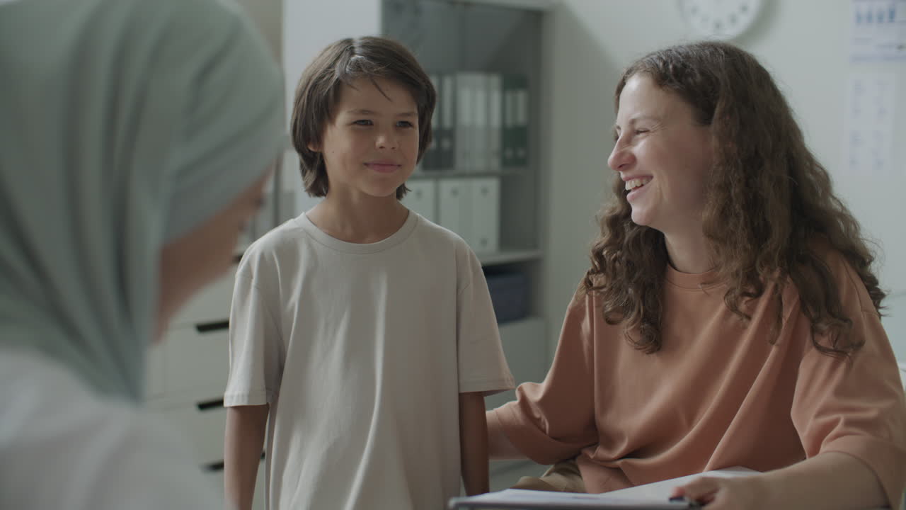 Woman with Child Having Consultation with Pediatrician in Medical Office