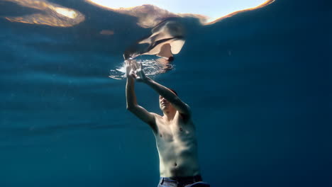 man reaching towards the light and surface underwater