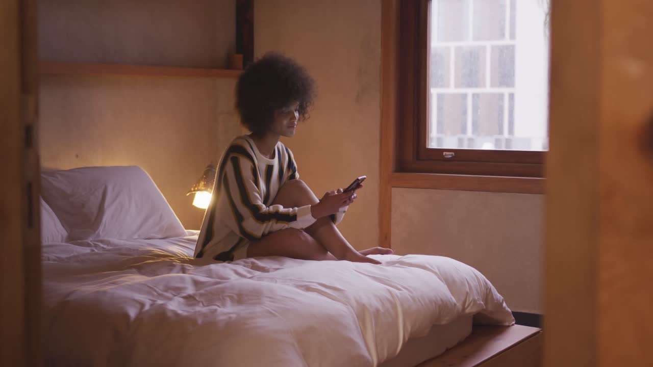 Mixed race woman texting at home