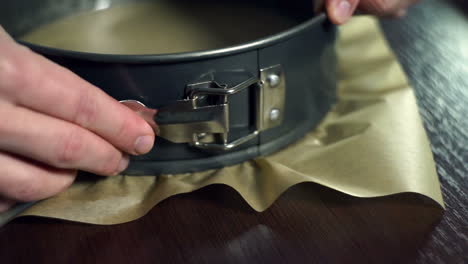 woman closes a round baking dish. preparing for baking cake